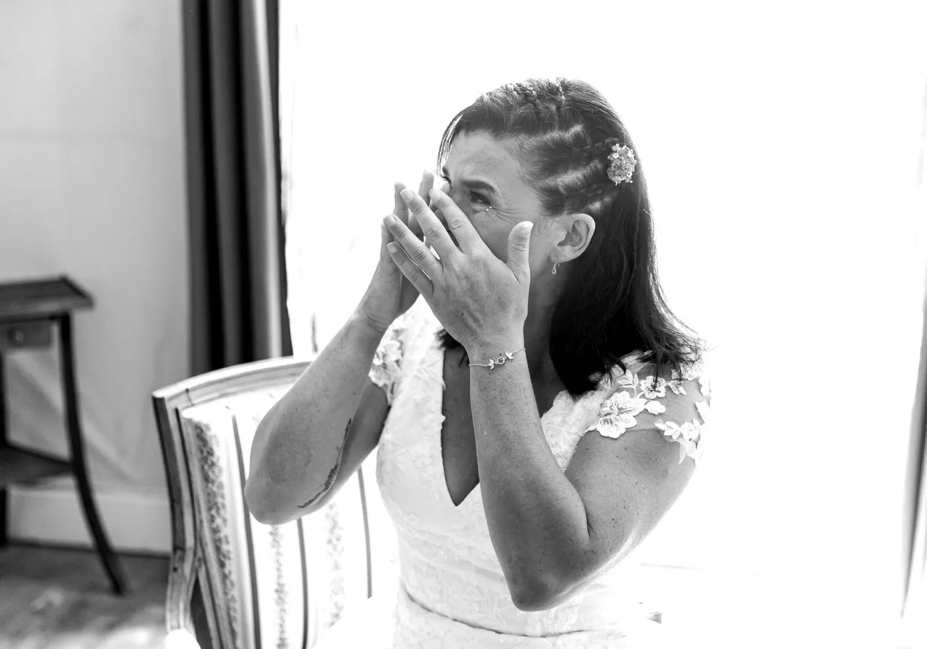 La mariée émue, le visage entre les mains
