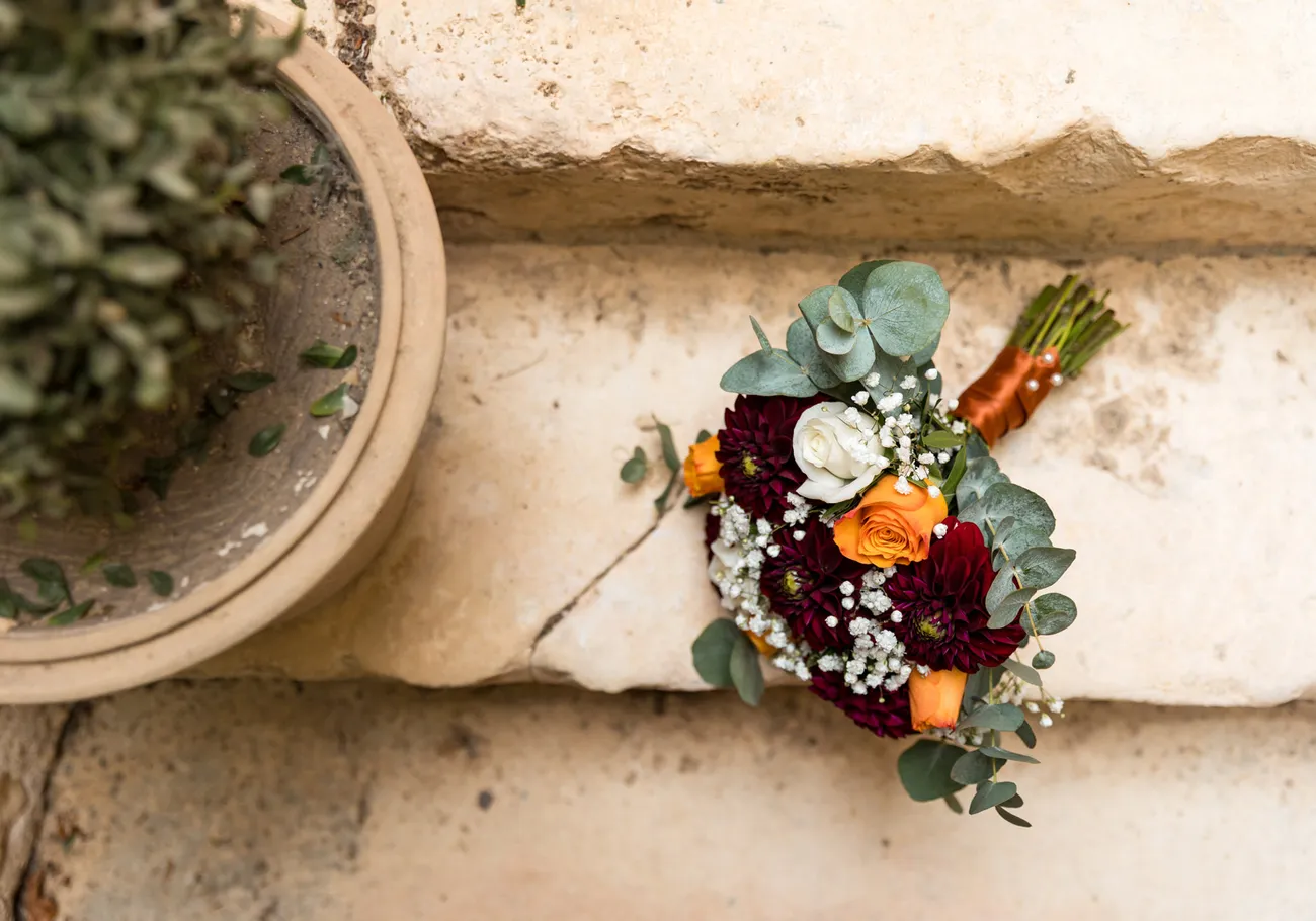 Le bouquet de la mariée posé sur une pierre ancienne